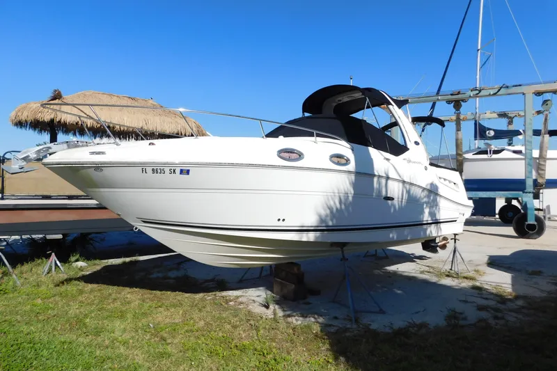 The Image of 2006 Sea Ray 260 Sundancer boat on dry dock under clear blue sky. - 0