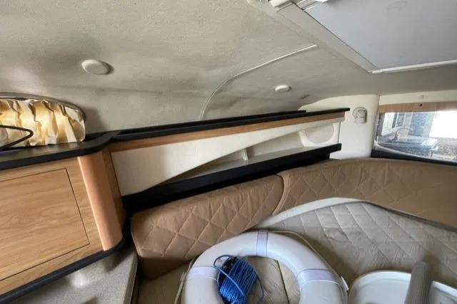 Slide: The Image of 2006 Sea Ray 260 Sundancer cabin interior with life preserver and storage compartments. - 16