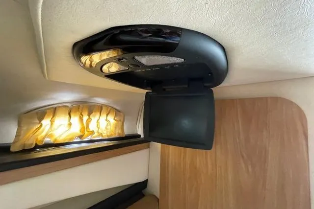 Slide: The Image of 2006 Sea Ray 260 Sundancer cabin with ceiling-mounted TV and ambient lighting. - 19