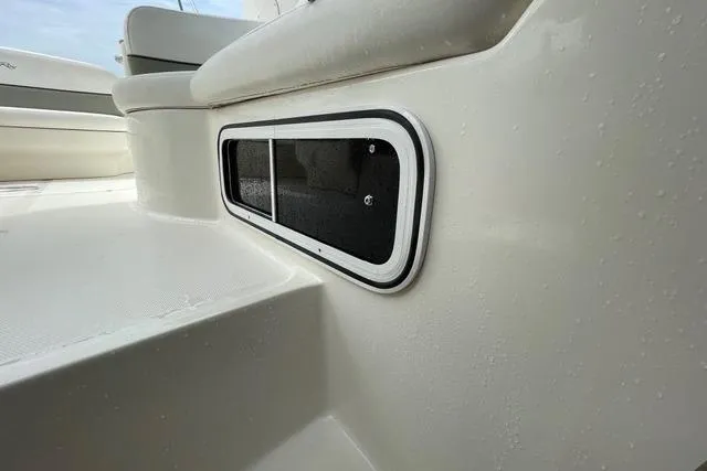 Slide: The Image of 2006 Sea Ray 260 Sundancer boat detail, featuring a sleek white exterior with a window. - 24