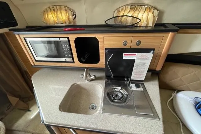 Slide: The Image of Compact kitchen area in a 2006 Sea Ray 260 Sundancer boat with microwave and stove. - 25