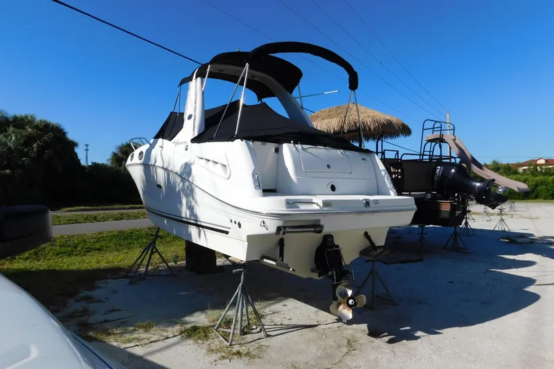 Slide: The Image of 2006 Sea Ray 260 Sundancer boat on stands, outdoor display under clear blue sky. - 4