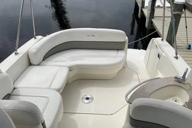 Slide: The Image of 2006 Sea Ray 260 Sundancer boat interior with white seating and small sink. - 9