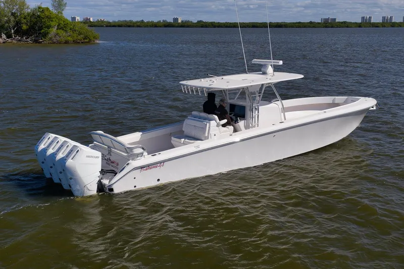 Slide: The Image of 2024 Bahama 41 RD boat cruising on a calm lake with four outboard engines. - 24