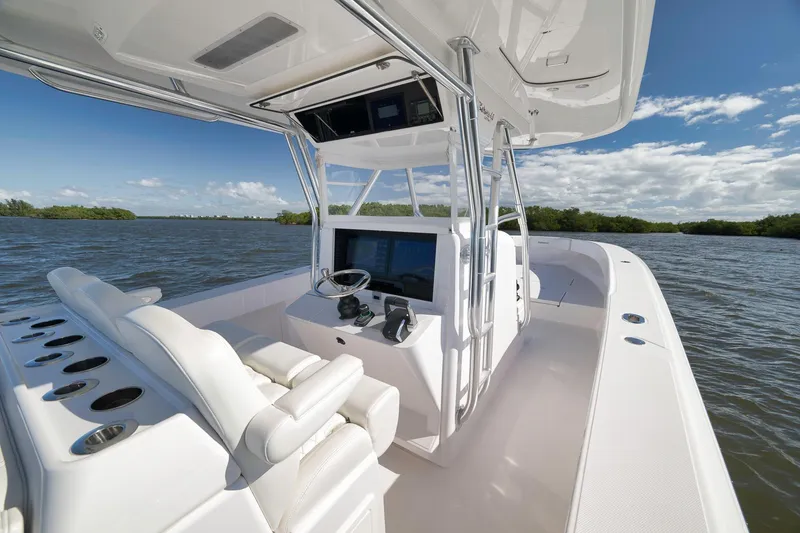 Slide: The Image of 2024 Bahama 41 RD boat interior with helm, white seating, and scenic water view. - 13
