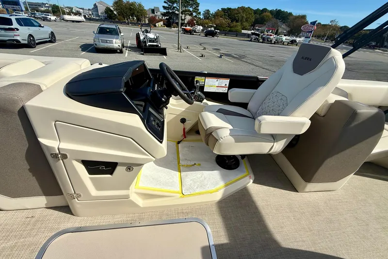 Slide: The Image of Captain's seat and helm of 2026 Alera M23 boat in a parking lot. - 13