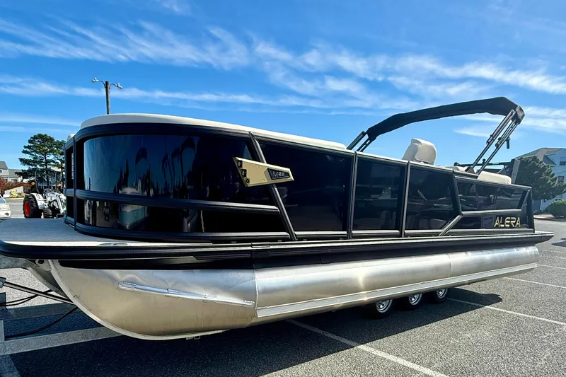 Slide: The Image of Alera M23 pontoon boat, 2026 model, parked outdoors under a clear blue sky. - 3