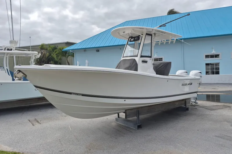 Slide: The Image of 2026 Regulator 23 boat on display, white hull, blue roof background. - 11