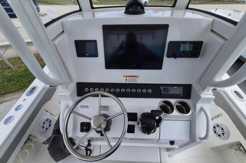 Slide: The Image of 2026 Regulator 23 boat dashboard with steering wheel, navigation screens, and controls. - 18