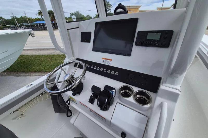 Slide: The Image of 2026 Regulator 23 boat dashboard with steering wheel, navigation screen, and controls. - 19