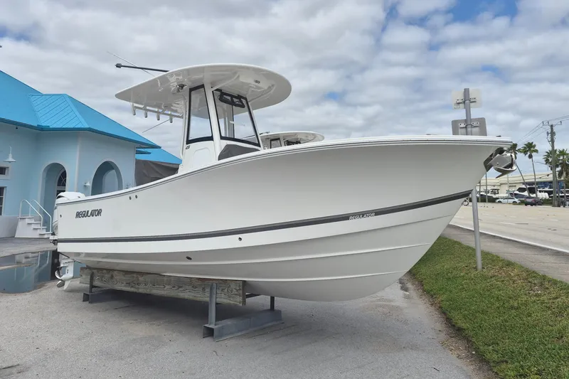 The Image of 2026 Regulator 23 boat displayed outdoors, featuring sleek white design and modern structure. - 9