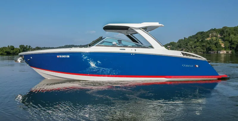 Slide: The Image of 2023 Cobalt R33 boat on calm water, blue and white design, side view. - 10