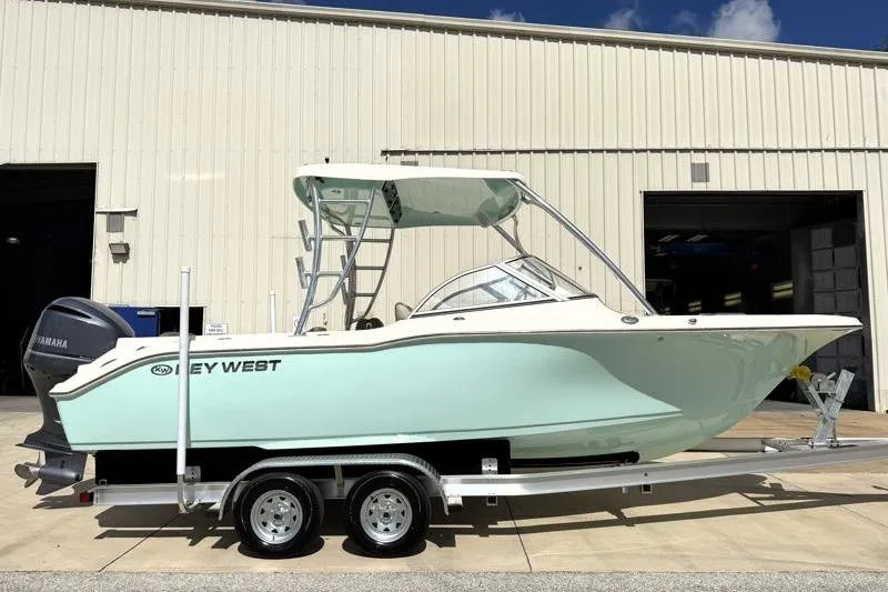 The Image of 2024 Key West 239 DFS boat on trailer, parked outside a warehouse. - 0