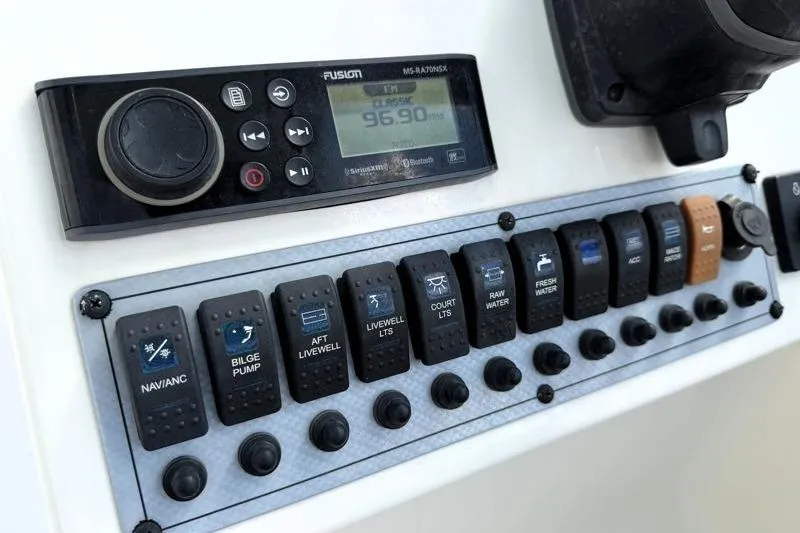 Slide: The Image of Control panel of 2024 Key West 239 DFS boat with switches and Fusion stereo system. - 22