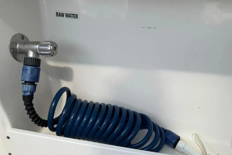 Slide: The Image of 2024 Key West 239 DFS raw water hose connection with coiled blue hose. - 34