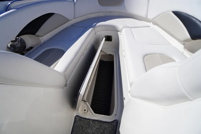 Slide: The Image of 2014 Chaparral 287 SSX boat interior with open storage compartment and cushioned seating. - 12
