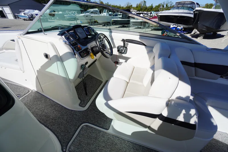 Slide: The Image of 2014 Chaparral 287 SSX boat interior with white seating and modern dashboard controls. - 14