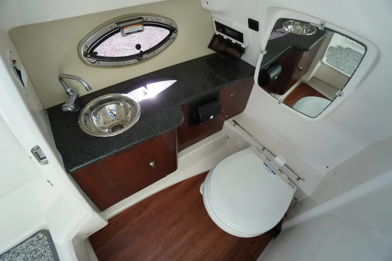 Slide: The Image of 2014 Chaparral 287 SSX boat bathroom with sink, mirror, and toilet. - 25