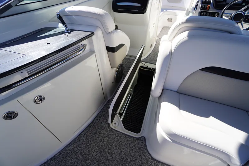 Slide: The Image of 2014 Chaparral 287 SSX boat interior with white seating and storage compartment. - 40