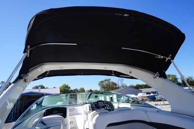Slide: The Image of 2014 Chaparral 287 SSX boat interior with black canopy and steering console. - 60