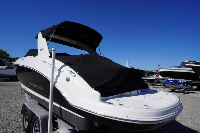 Slide: The Image of 2014 Chaparral 287 SSX boat with black cover on trailer, under clear blue sky. - 61