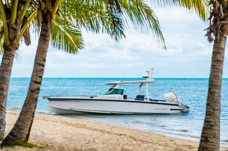 The Image of 2025 Axopar 29 Sun Top boat anchored on tropical beach with palm trees. - 0