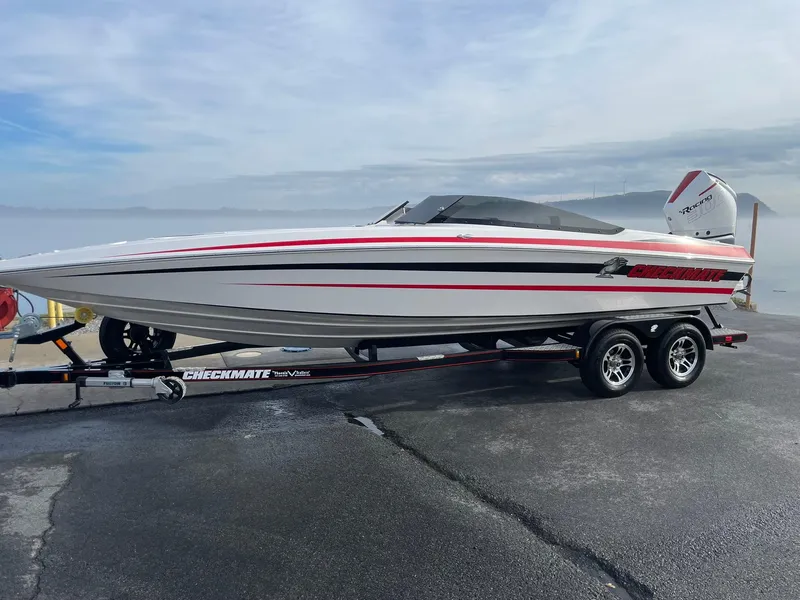 The Image of 2025 Checkmate Pulsare 2400 BRX boat on trailer, sleek design with red accents. - 1