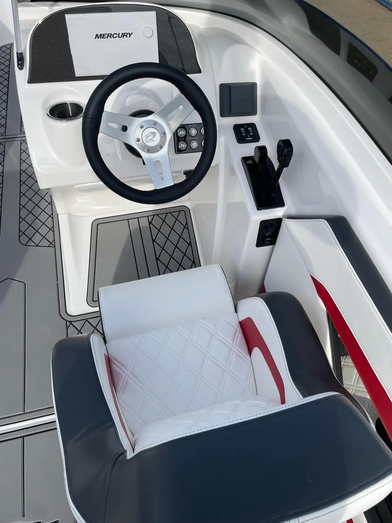 Slide: The Image of 2025 Checkmate Pulsare 2400 BRX boat cockpit with steering wheel and seating. - 11