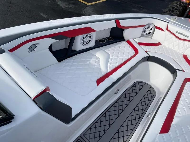 Slide: The Image of 2025 Checkmate Pulsare 2400 BRX boat interior with red and white seating and speakers. - 17