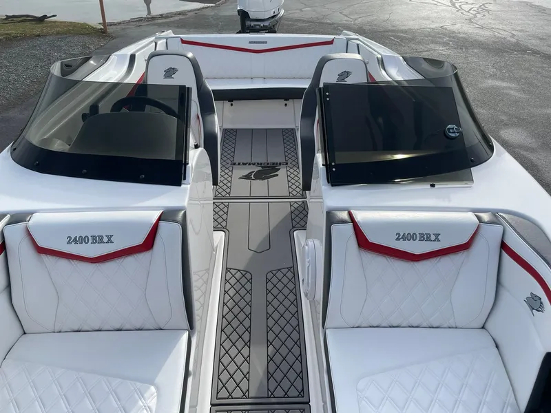 Slide: The Image of 2025 Checkmate Pulsare 2400 BRX boat interior with white and red seating. - 19