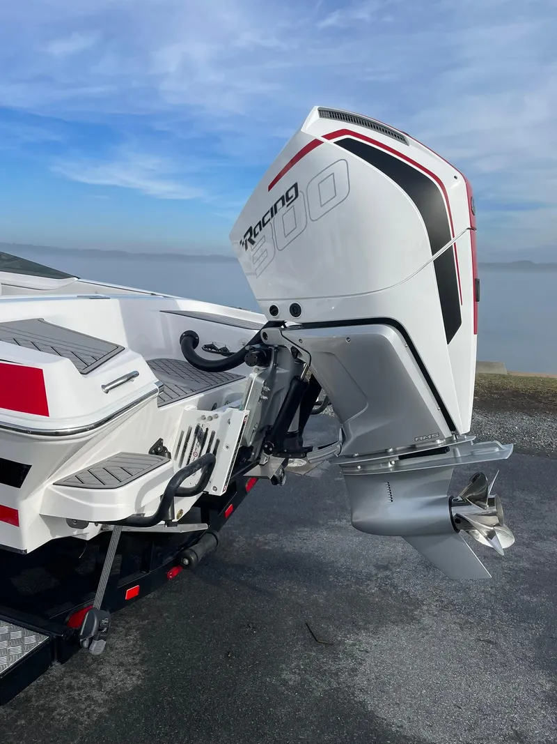 Slide: The Image of 2025 Checkmate Pulsare 2400 BRX boat with powerful outboard motor, docked by the water. - 3