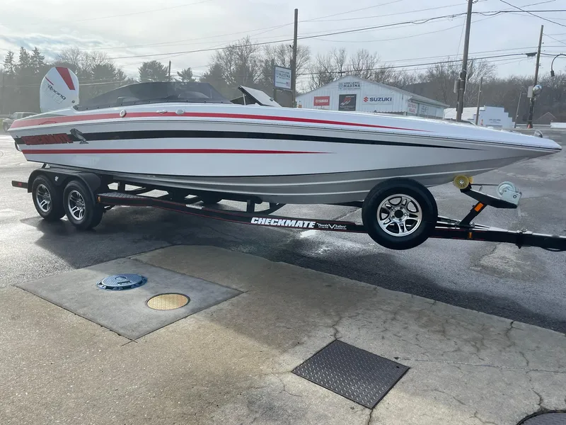 Slide: The Image of 2025 Checkmate Pulsare 2400 BRX boat on trailer, sleek design with red and black accents. - 7