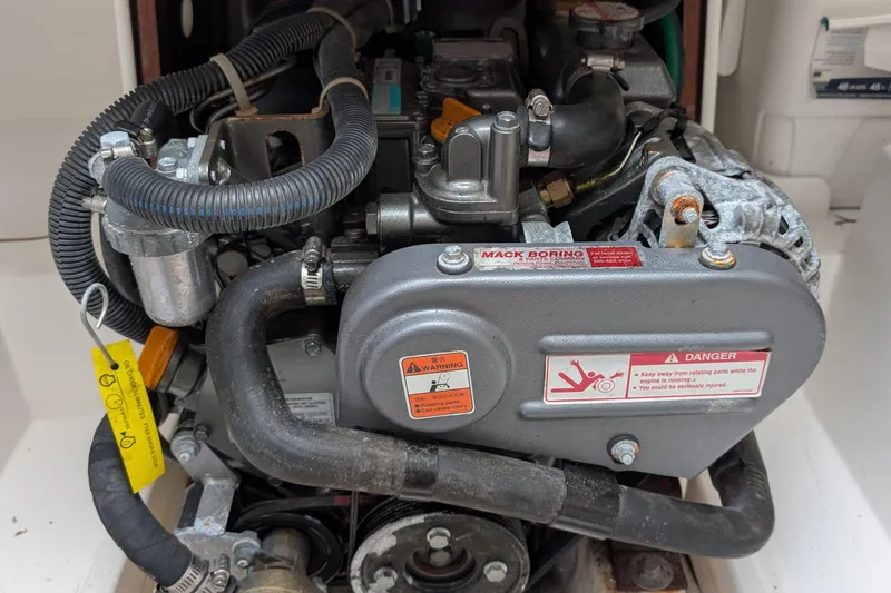 Slide: The Image of Engine compartment of a 2016 J Boats J 95 sailboat, featuring detailed components and warning labels. - 24