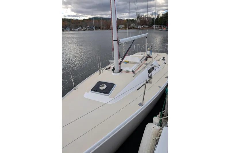 Slide: The Image of 2016 J Boats J 95 sailboat docked on a calm lake under cloudy skies. - 4