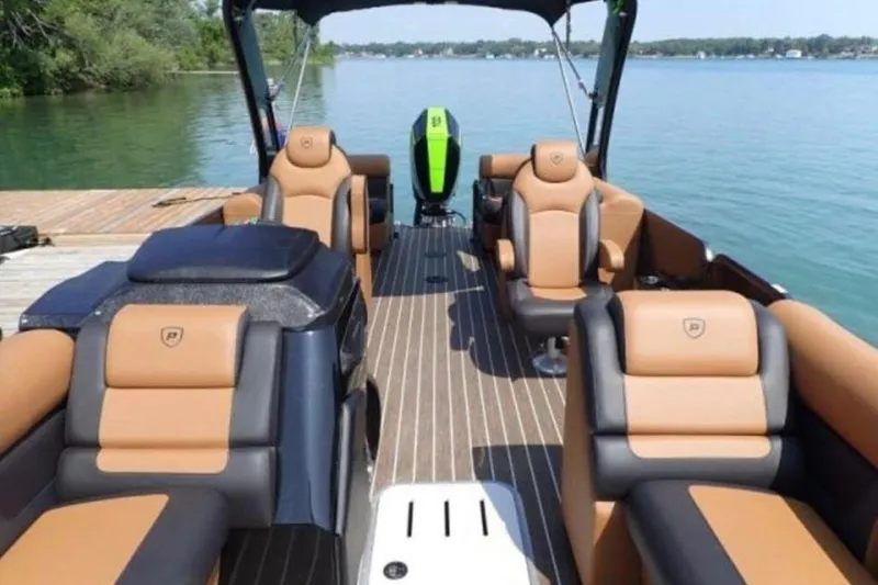 Slide: The Image of 2025 Premier 250 Solaris RF boat interior with luxurious seating on a serene lake. - 11