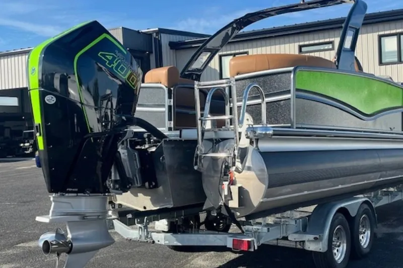 Slide: The Image of 2025 Premier 250 Solaris RF pontoon boat with powerful outboard motor on trailer. - 13