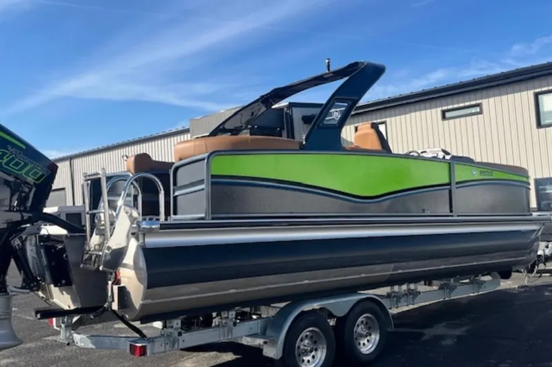 Slide: The Image of 2025 Premier 250 Solaris RF pontoon boat on trailer, featuring green and gray design. - 14