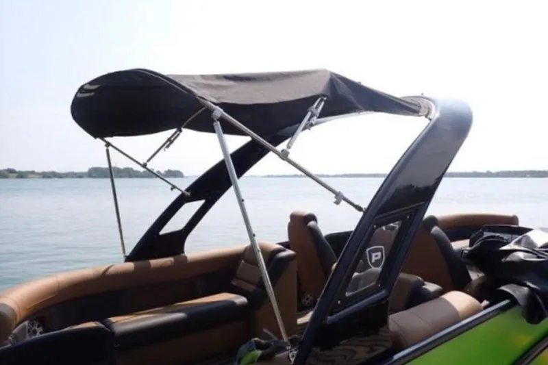 Slide: The Image of 2025 Premier 250 Solaris RF pontoon boat with canopy on a serene lake. - 6