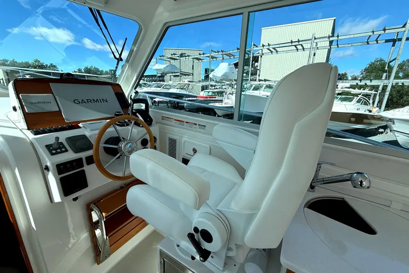 Slide: The Image of 2024 Back Cove 34O boat cruising on a sunny day with scenic water backdrop. - 11