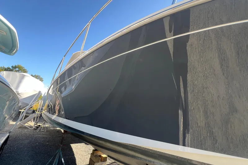 Slide: The Image of 2024 Back Cove 34O boat on calm water under a blue sky with clouds. - 3