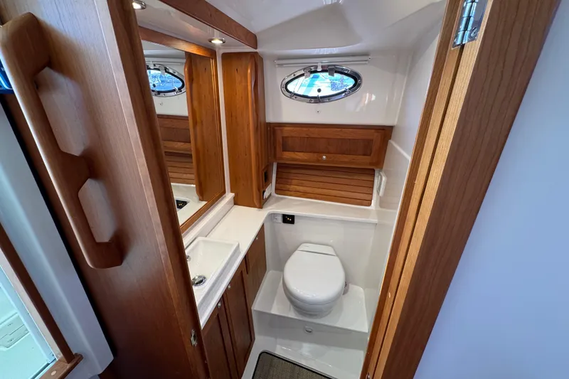 Slide: The Image of Helm of 2024 Back Cove 34O boat with wooden steering wheel and navigation controls. - 34