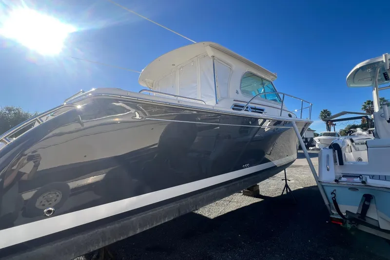 Slide: The Image of 2024 Back Cove 34O boat on calm water under a partly cloudy sky. - 4