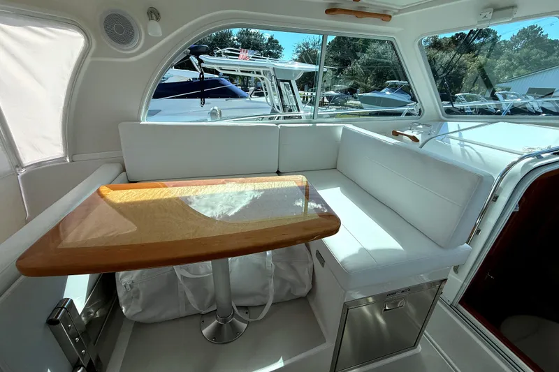 Slide: The Image of 2024 Back Cove 34O interior with white seating and wooden table. - 44