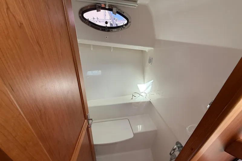 Slide: The Image of 2024 Back Cove 34O boat interior bathroom with wooden door and porthole window. - 46