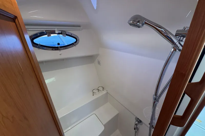 Slide: The Image of 2024 Back Cove 34O yacht bathroom with shower and porthole window. - 47