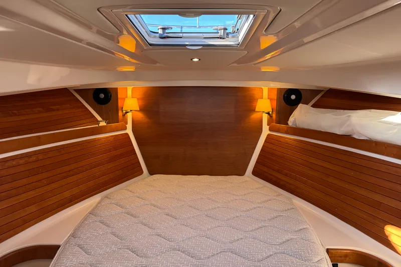 Slide: The Image of 2024 Back Cove 34O cabin interior with wood paneling and skylight. - 52