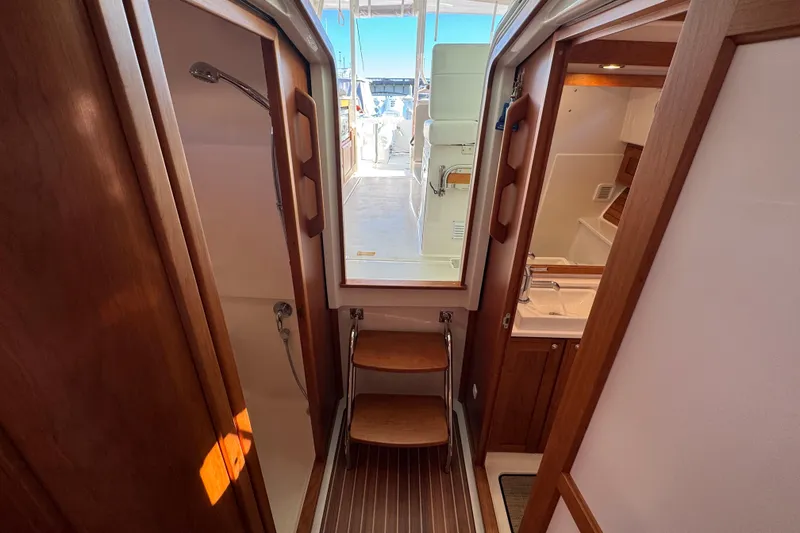 Slide: The Image of 2024 Back Cove 34O yacht interior with wooden finishes and compact bathroom. - 54