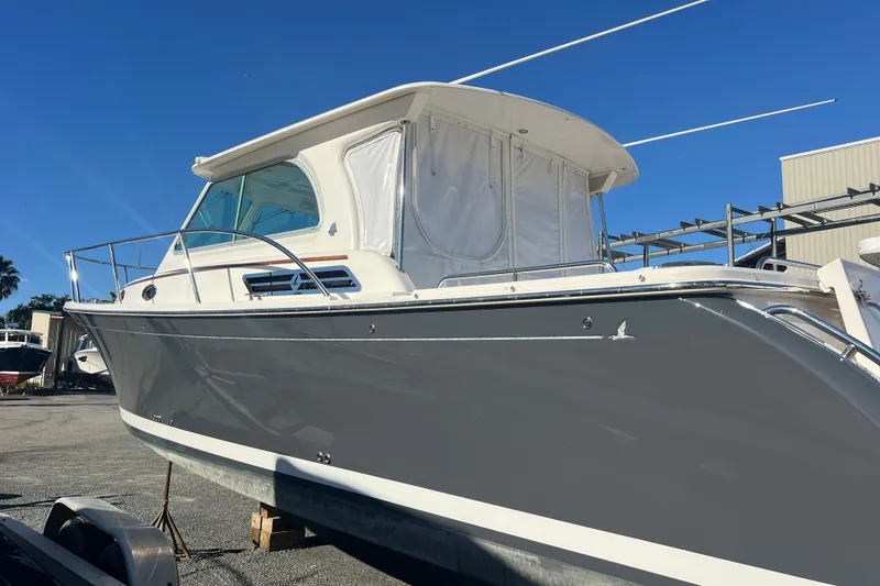 Slide: The Image of 2024 Back Cove 34O boat with sleek gray hull, docked under clear blue sky. - 57