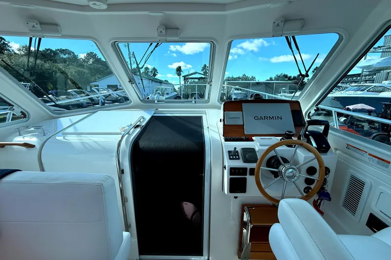 Slide: The Image of 2024 Back Cove 34O boat cruising on a sunny day with a bridge in the background. - 6