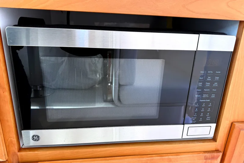 Slide: The Image of 2024 Back Cove 34O boat on calm water under a partly cloudy sky. - 8